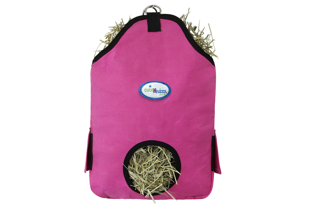 A pink fabric pet playpen or hay rack with black trim, featuring a circular hay opening at the bottom and hay stuffed into the top and inside the opening. A blue and white 'CareHazy' logo patch is visible on the front, set against a plain white background.