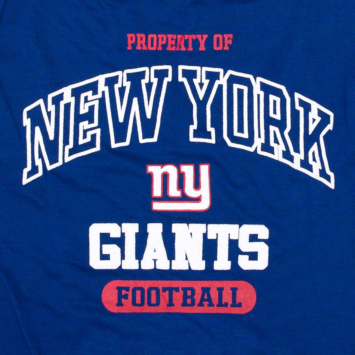 Close-up of a royal blue graphic pet t-shirt featuring the New York Giants logo and text. The design includes 'PROPERTY OF NEW YORK' in white and red, the 'ny' logo, 'GIANTS' in white, and 'FOOTBALL' in red.
