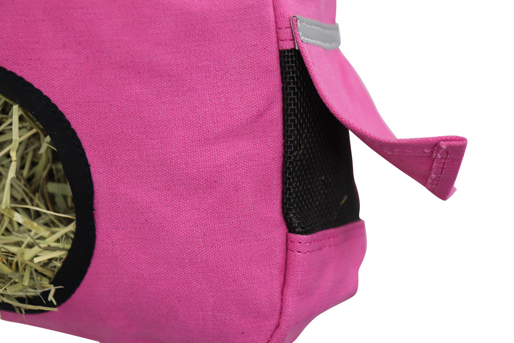 Close-up of a pink fabric pet playpen or hide with a black mesh side panel, a small flap tab, and a hay opening on a white background.