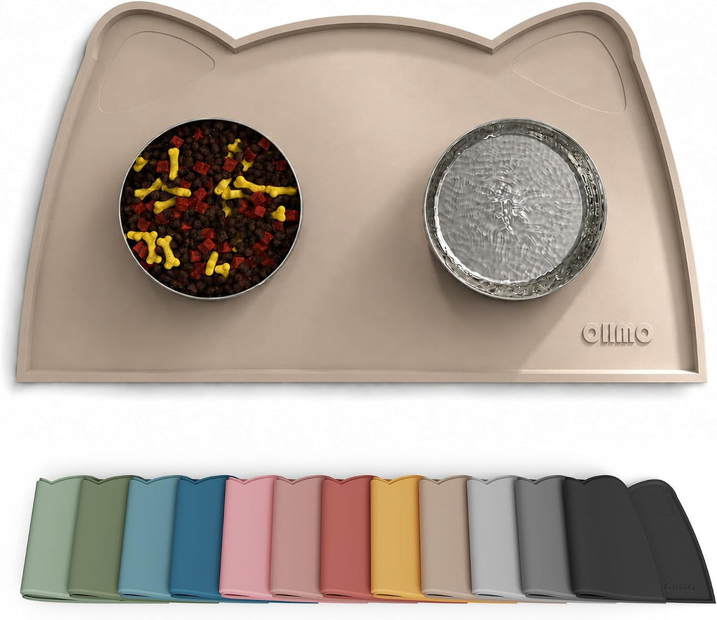 A beige cat-shaped silicone feeding mat with two bowls placed on it, shown on a white background. Below the main mat is a row of color options for the same mat in multiple shades.