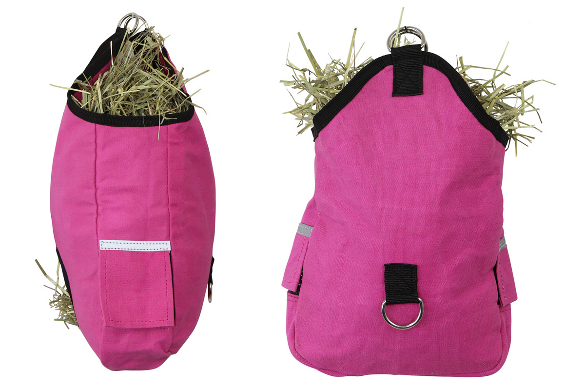 A bright pink pet harness shown from the front and side, filled with hay, on a plain white background. The harness has black trim, a silver metal ring at the top, and reflective silver stripes.