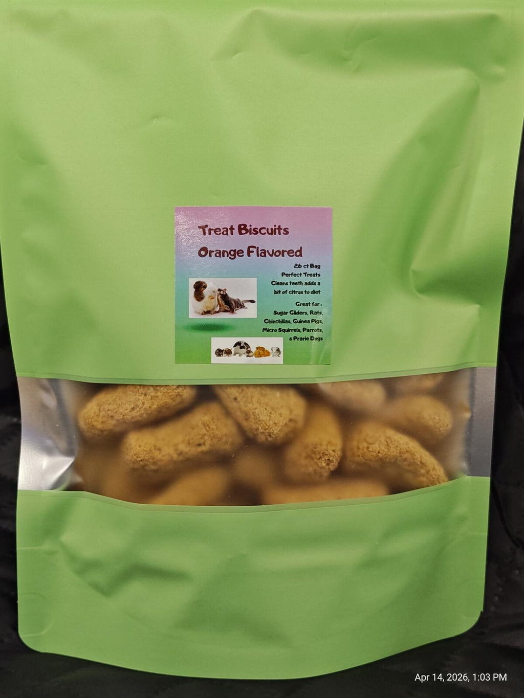 Green bag of orange-flavored treat biscuits for dogs with a label on a black background.