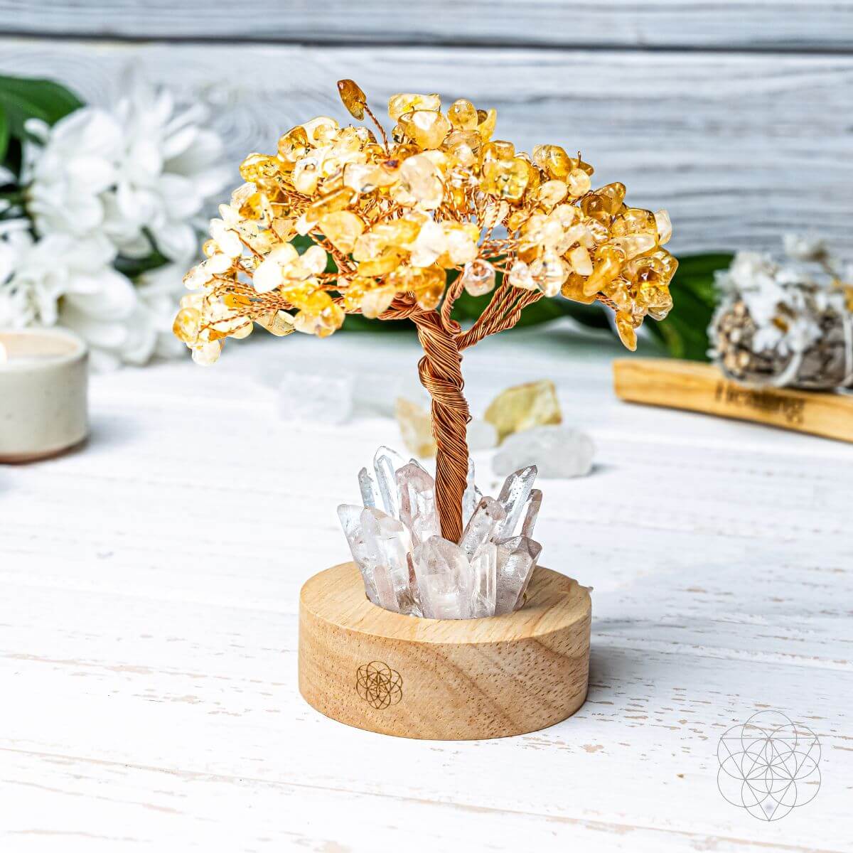 Citrine stone-chip tree with twisted copper branches and clear quartz points on a wooden lamp base in daylight.
