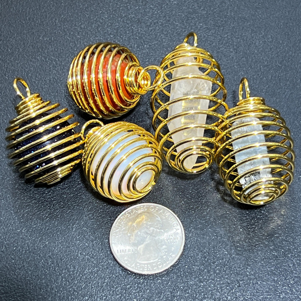Gold-finish spiral cage pendants holding assorted stones for demonstration beside a quarter for scale