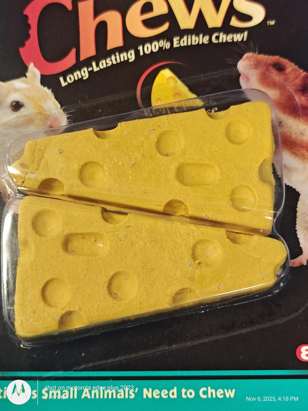 A packaged pet chew toy shaped like a yellow cheese wedge with circular holes, shown in clear plastic blister packaging on a black printed backing card with hamster illustrations and the word 'Chews' at the top.