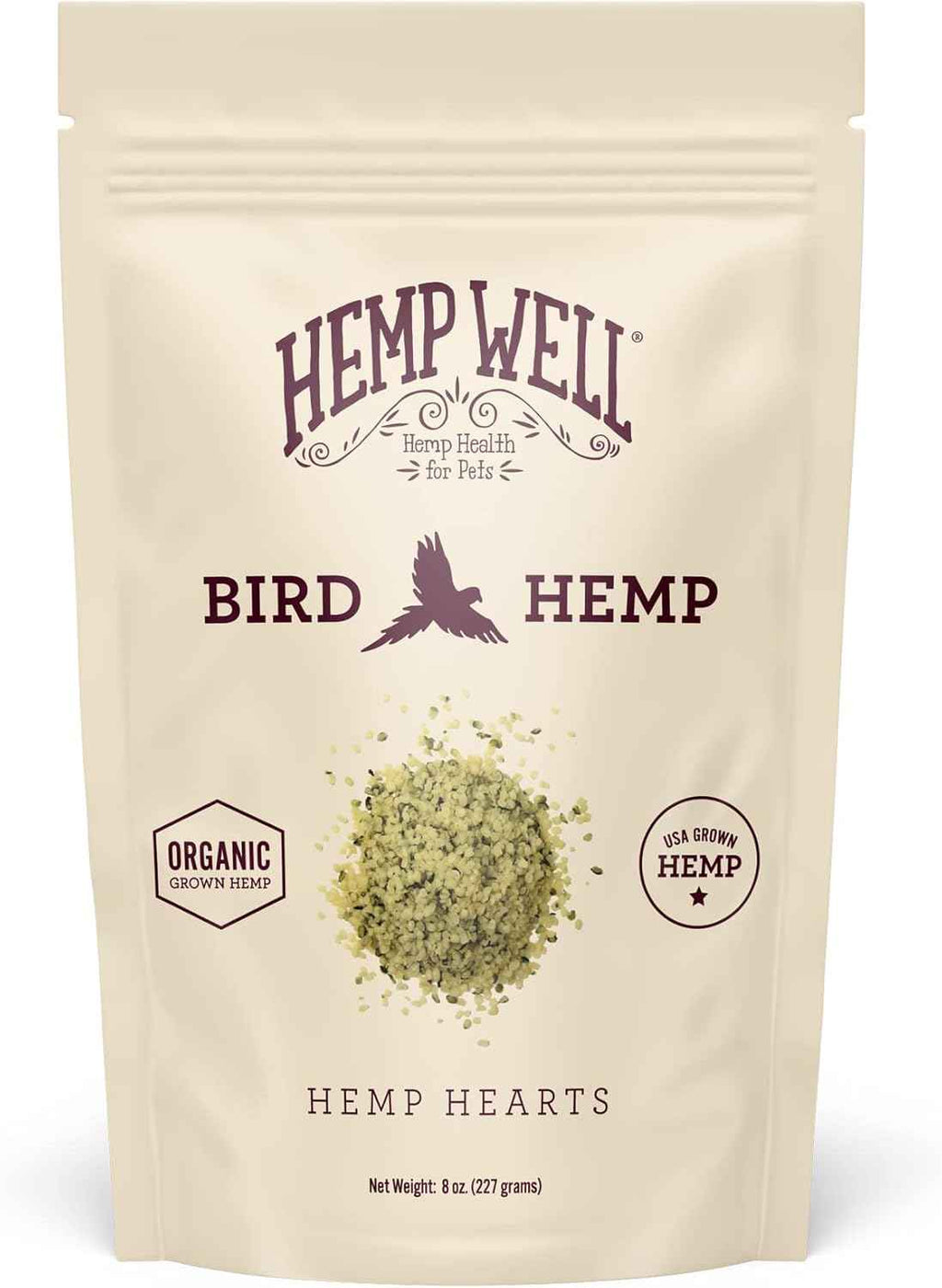 A stand-up pouch of Hemp Well Bird Hemp, labeled 'Hemp Hearts,' on a plain white background. The cream-colored bag features dark purple text and a small pile of greenish-yellow hemp hearts shown near the center.