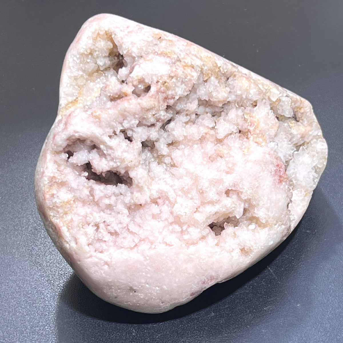 Pale pink amethyst standing freeform with sparkling druzy clusters, natural cavities and a polished outer edge