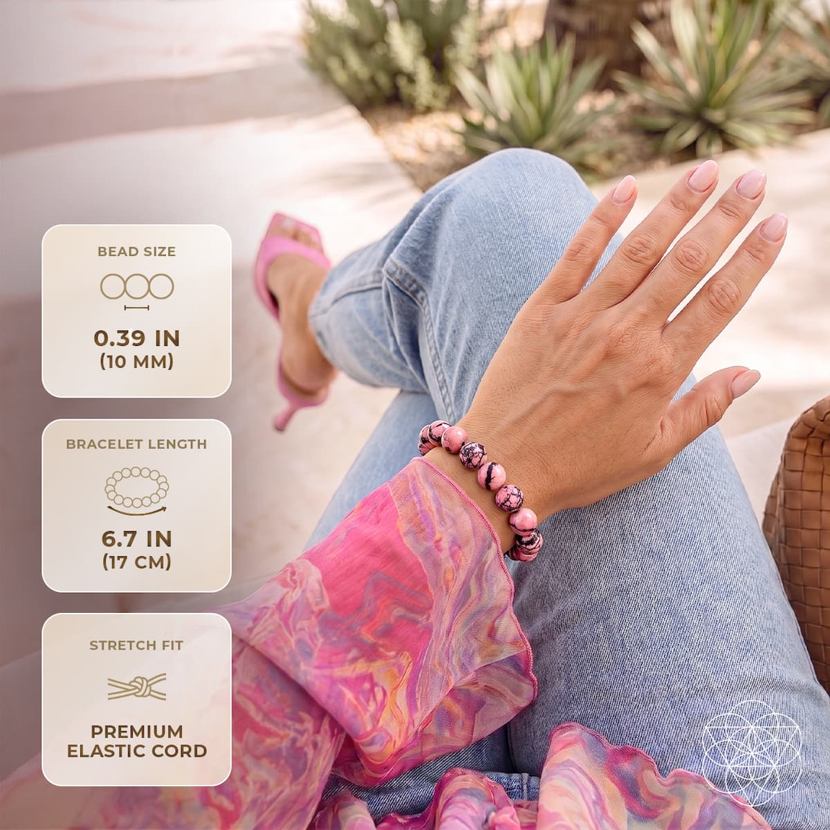 Rhodonite bracelet worn with jeans, with labels for 10 mm beads, 17 cm length, and elastic stretch cord.
