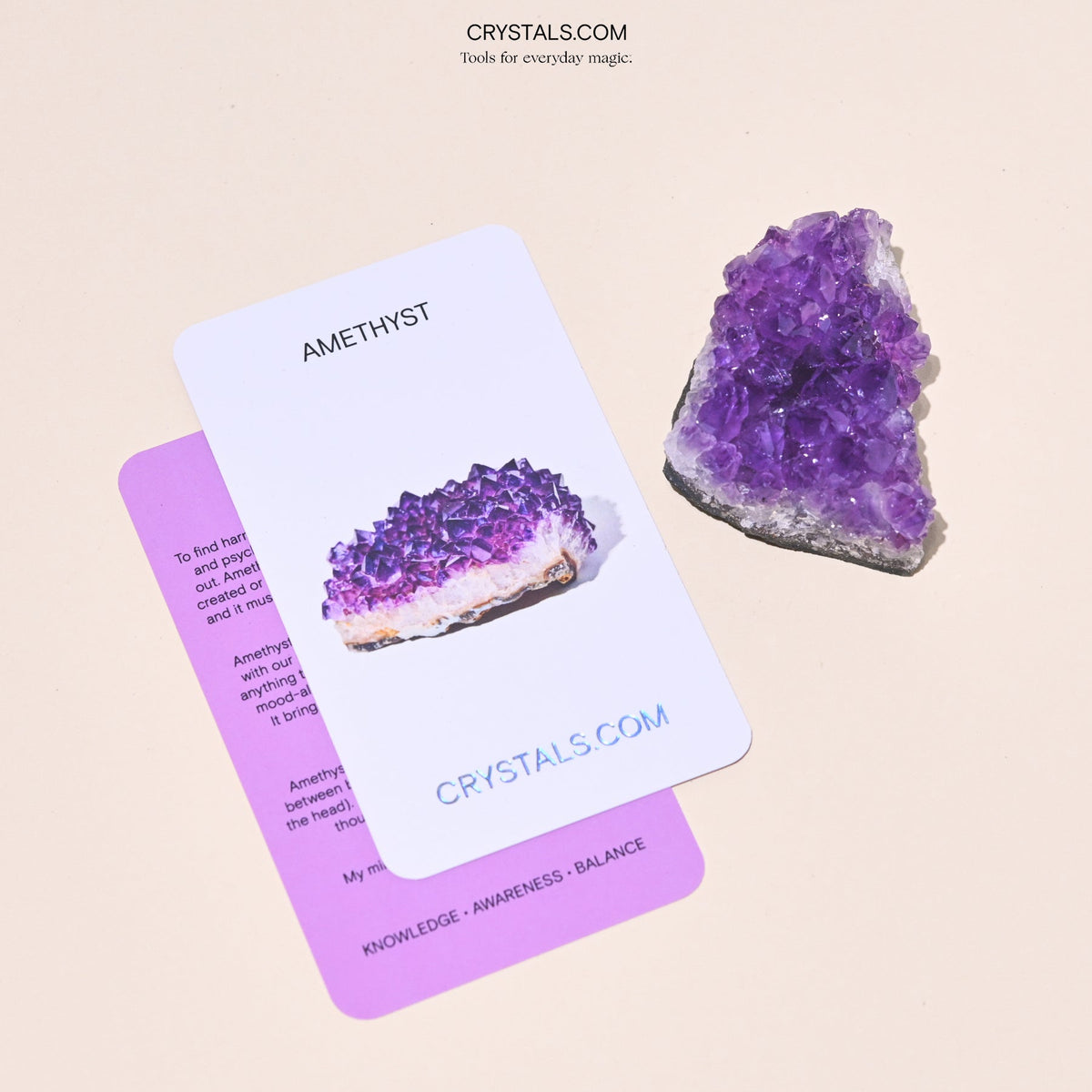 Tall triangular purple amethyst cluster beside two Amethyst collector cards on pale pink.
