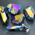 Titanium aura quartz clusters and rough points with reflective purple, blue, and gold surfaces on a dark background.
