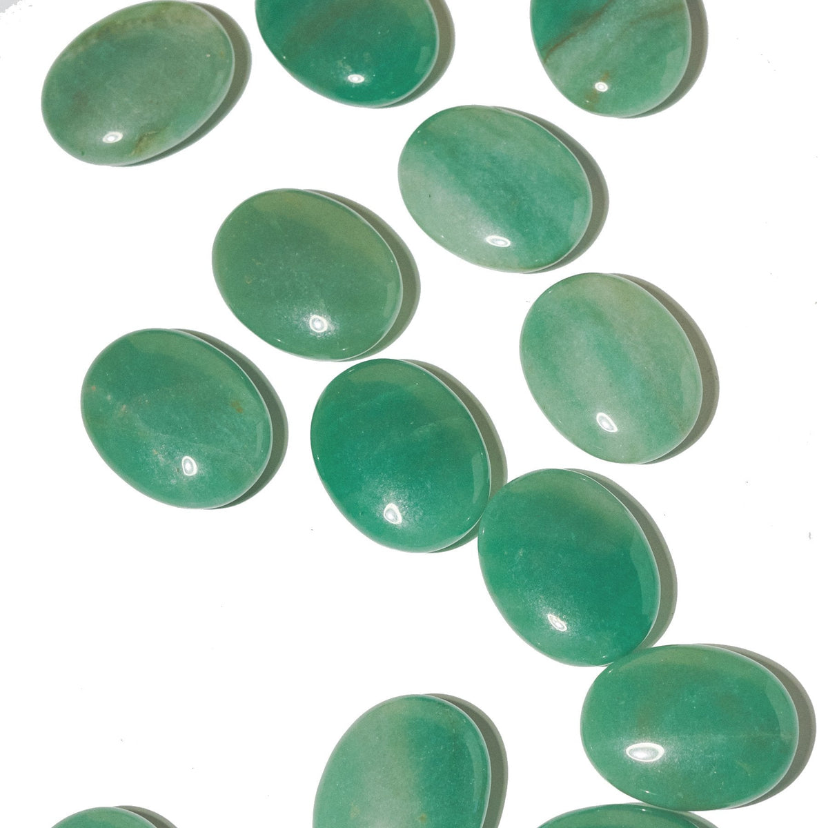 Overhead view of green aventurine palm stones with glossy surfaces and pale green cloudy patterns.
