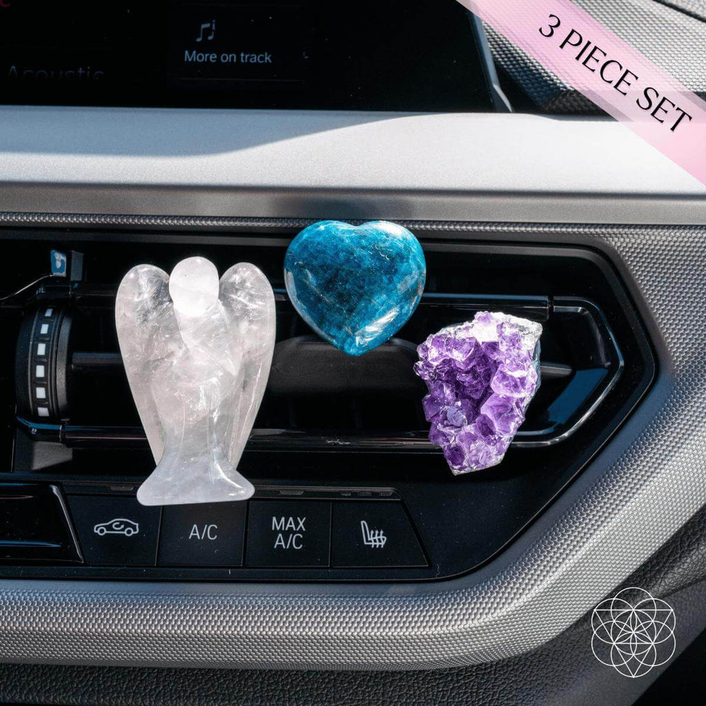 Clear Quartz angel, blue Apatite heart, and purple Amethyst cluster clipped to a car air vent.