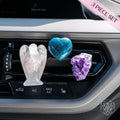 Clear Quartz angel, blue Apatite heart, and purple Amethyst cluster clipped to a car air vent.