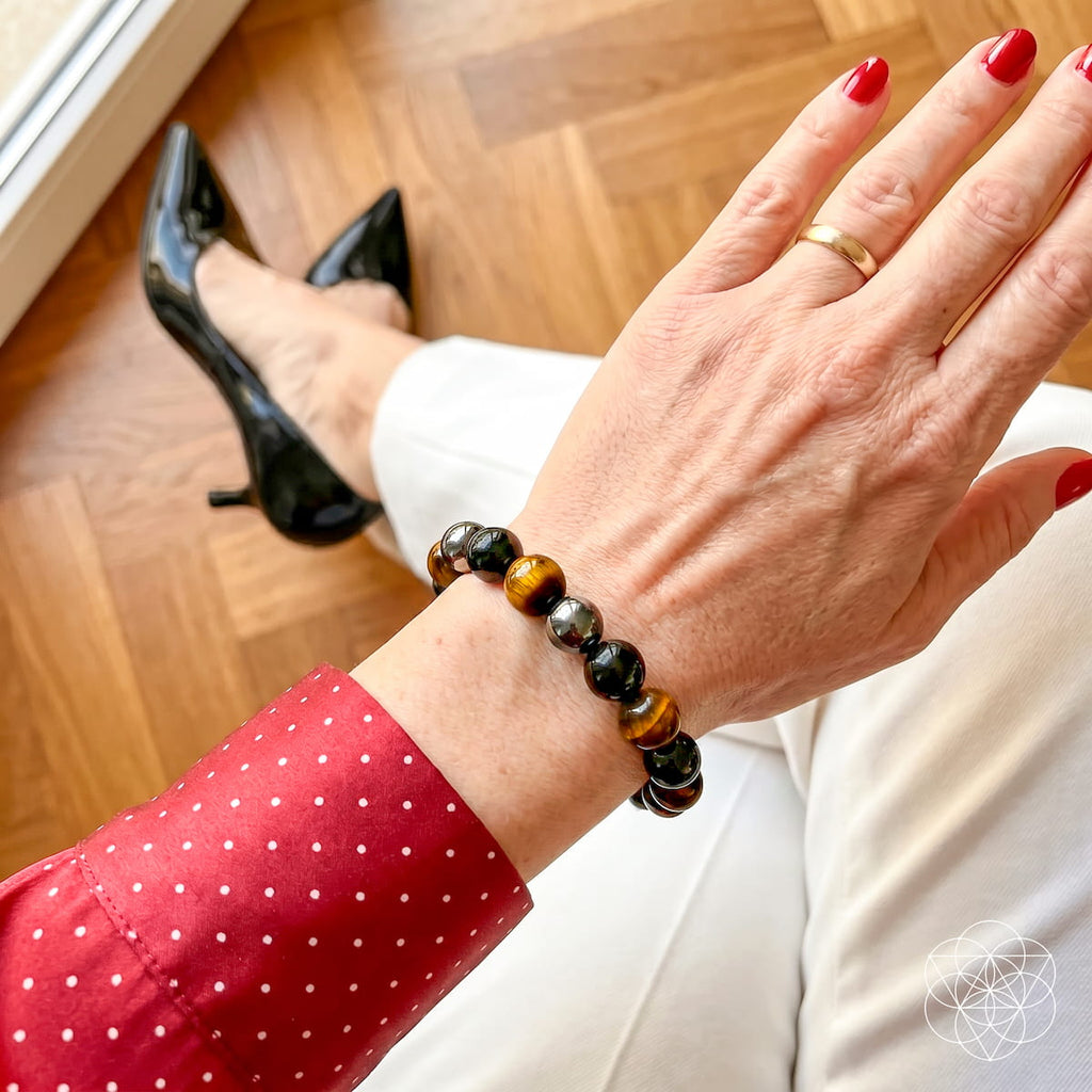 Close-up of the three-stone bracelet worn with a red polka-dot blouse and white pants.