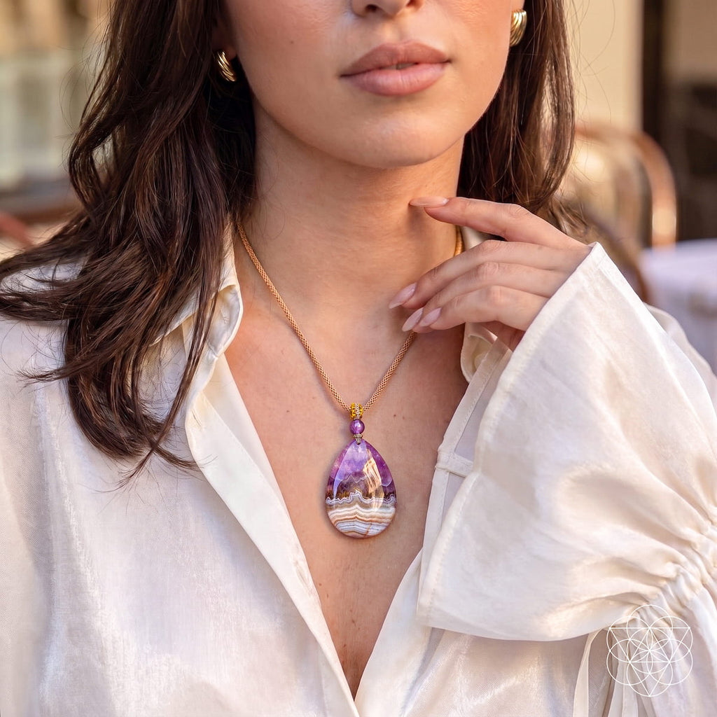Model wearing the purple amethyst and banded crazy lace agate pendant with a white blouse.