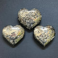 Three metallic pyrite puffy heart carvings with polished surfaces and druzy crystal pockets on a dark background.