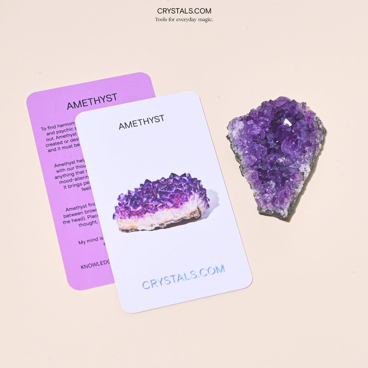 Purple amethyst cluster beside overlapping white and purple Amethyst collector cards.
