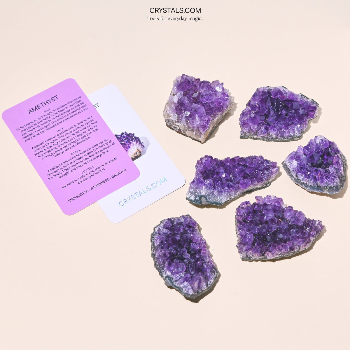 Six purple amethyst clusters of varied shapes arranged beside collector cards.
