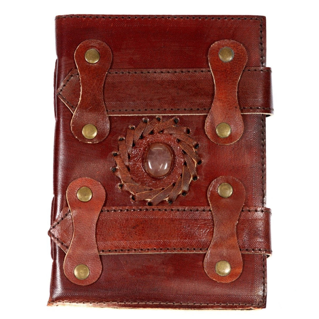 Brown leather journal with a rose quartz centerpiece, braided leather ring, layered straps and metal rivets