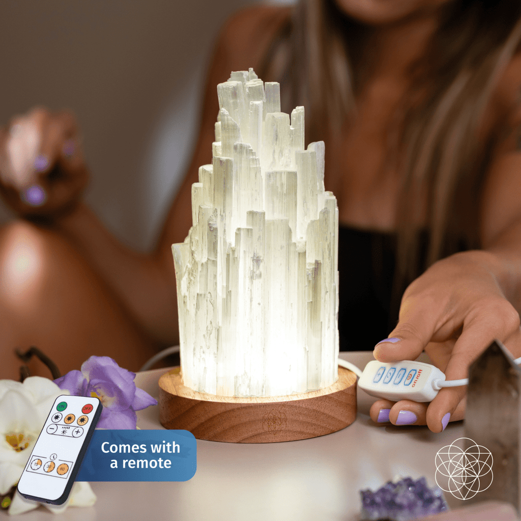 Person holding the wired inline controls beside a glowing selenite tower lamp, with an included remote callout.
