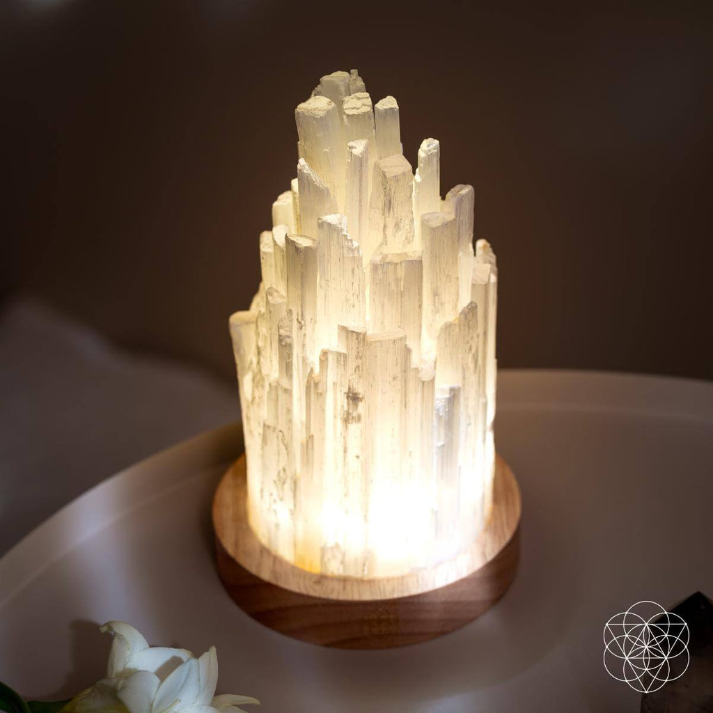 Angled close-up of the stepped white columns and vertical texture of a glowing selenite tower lamp.
