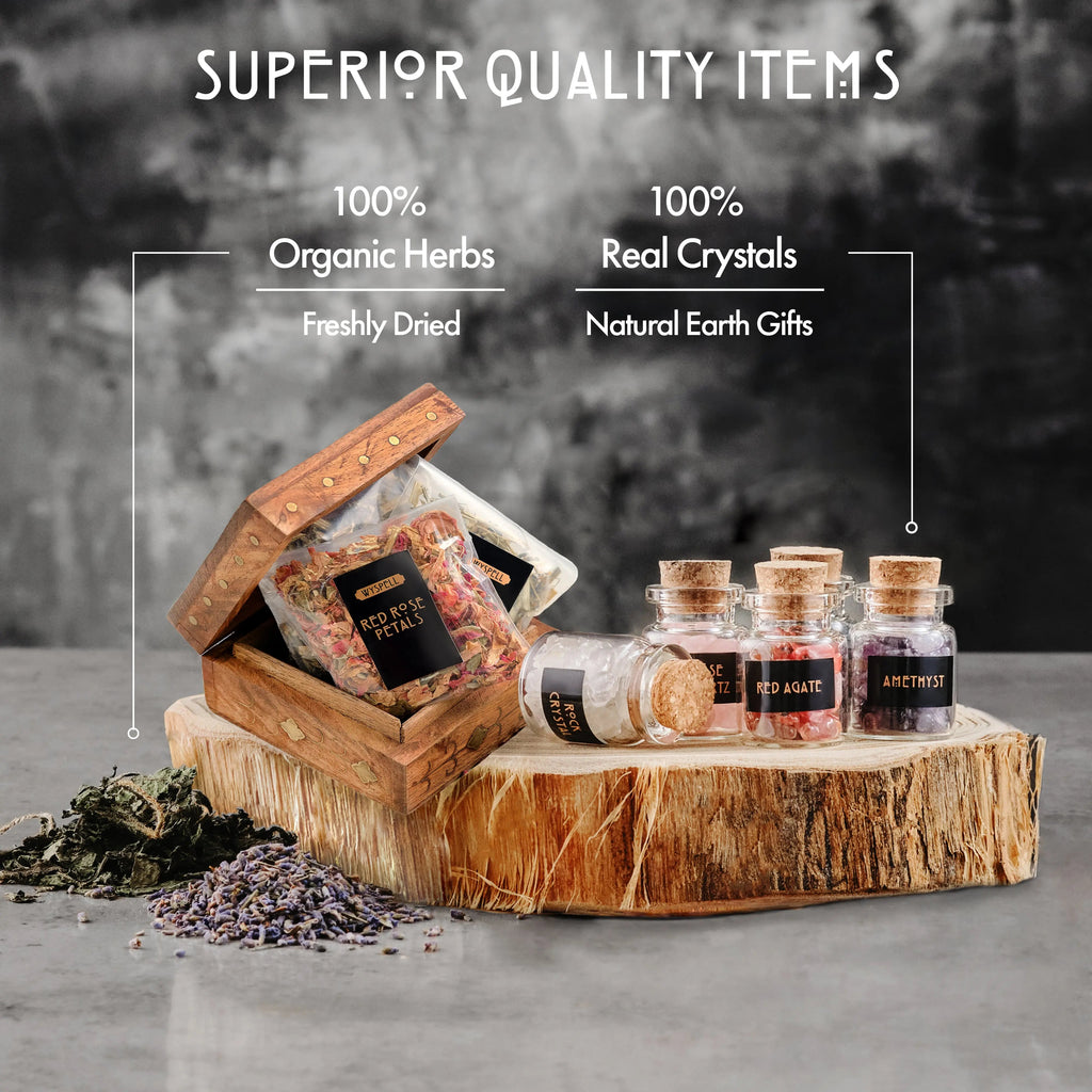 Dried herb packets in a wooden box beside corked crystal jars and loose herbs on a wood slice.
